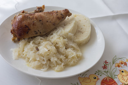 Roasted duck leg with yeast dumpling and cabbage on a white plate. Tasty lunchの写真素材