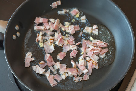 Chopped bacon is fried in a panの写真素材