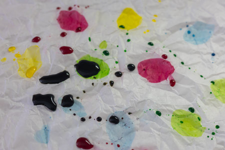 An abstract close-up shot of crumpled white paper or plastic surface, splattered with drops and...