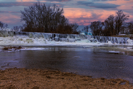 Spectacular ice formations and massive icicles on the CvrÄovice dam on the Jihlava River. The photos capture the harsh winter beauty of the Czech landscape, featuring the contrast between frozen ice cascades and cold flowing water during a winter freezeの写真素材