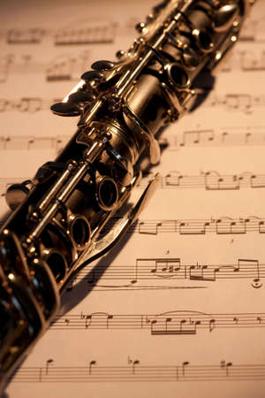 A close up of a clarinet with sheet music under itの写真素材