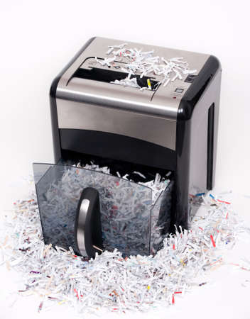 An open paper shredder with shredded paper all aroundの写真素材