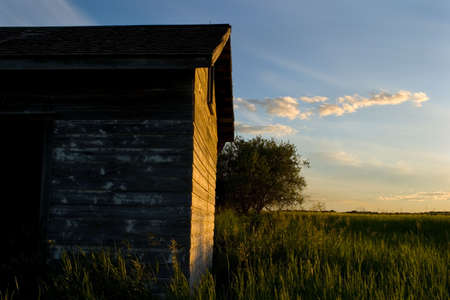 An old weathered building with the sun shining on itの写真素材
