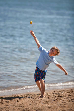 A seven year old boy throwing a ballの写真素材
