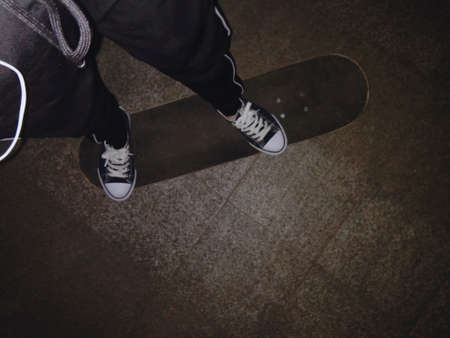Skateboarder legs on skateboard. Top view. Copy space.の写真素材
