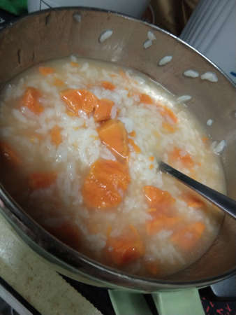 Rice porridge with pumpkin in a pan on the table.の写真素材