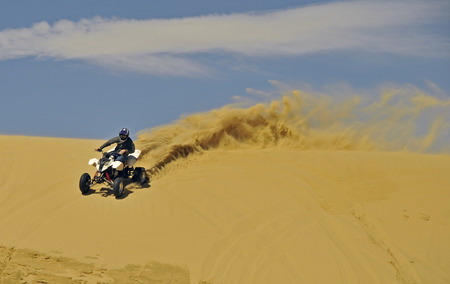sportquad riding in the sand near the beach or ocean