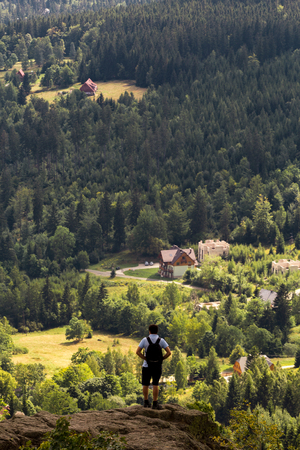 a man standing on the edge of a rock in the mountains with the view belowの写真素材