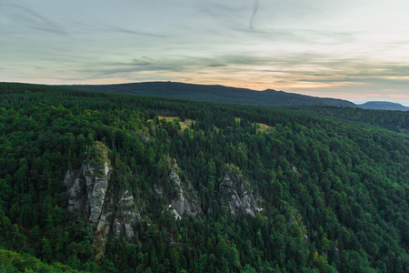 Beautiful calm sunrise over forest in mountains, near Frydlantske Cimburi rock formation, Hejnice, Czech Republicの写真素材