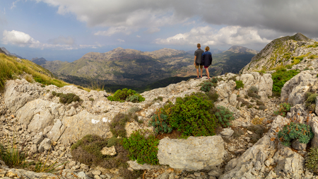 People hiking in front of mountain panorama in Serra de Tramuntanaの写真素材