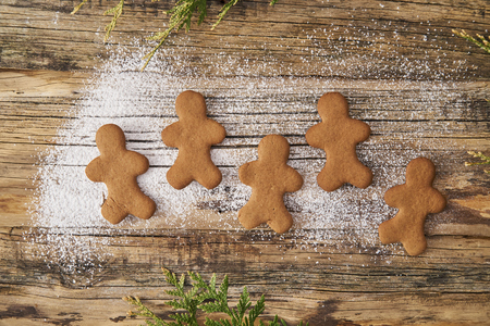 Family love Christmas homemade gingerbread sprinkled with powdered sugar on a wooden background with spruce needlesの写真素材