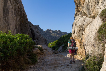 Young, beautiful, teenage woman with backpack hiking in mountains. Serra de Tramuntana, Mallorca, Spainの写真素材