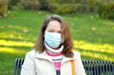 Woman in a medical mask on natureの写真素材