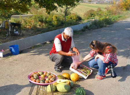 A woman buys grapes on the roadsideのeditorial素材