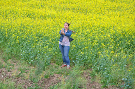 A woman takes a selfie at the edge of a rapeseed field. Russia