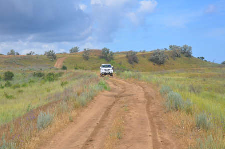 KRASNODAR KRAY, RUSSIA - JUNE 21, 2020: Dirt road and white UAZ Patriot SUVのeditorial素材