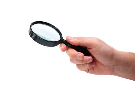 Hand holding magnifying glass isolated on white backgroundの写真素材