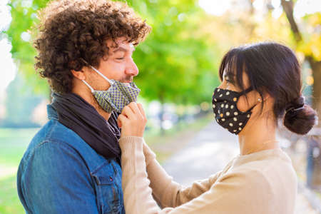 Multiracial couple having tender moments outdoor in a park during autumn after lockdown...