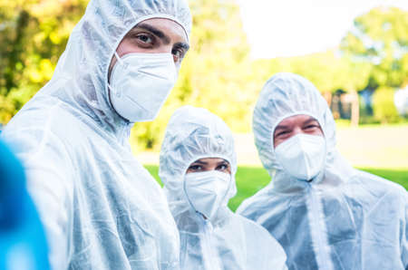 group of environmentalists volunteer wearing gloves and protective face mask taking a selfie outdoor after the lockdown reopening.ecologists in a park.concept about sesibilization new normal lifestyleの写真素材