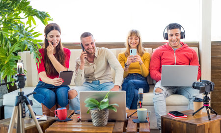 Addicted multicultural group of friends ignoring live communication while chatting in social networks or smartphones using wireless 5G internet at home.four people overwhelmed with technology.lifestyleの写真素材
