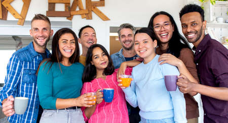 young multiethnic group of friends portrait celebrating breakfast and coffee in a hotel sky bar having fun together at restaurant indoor on vacation holiday. group of diverse people cheering in party.の写真素材