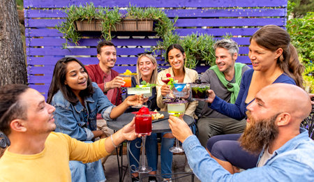 happy diverse group of friends celebrating new year eve making a celebratory toast clinking...