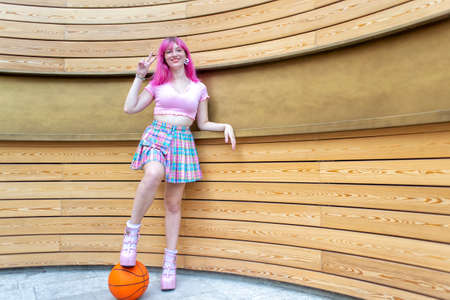 close up portrait of alternative woman with pink hair hanging out chilling and smiling standing...