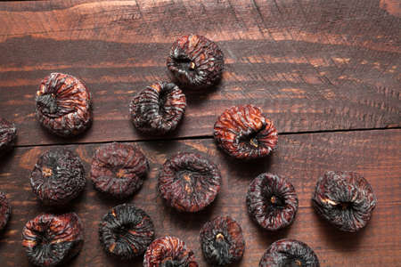 Dried black figs on a wooden surface