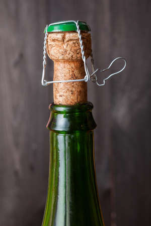 Champagne bottle with cork on black wooden backgroundの写真素材