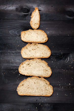 Bread slices on black wooden tableの写真素材