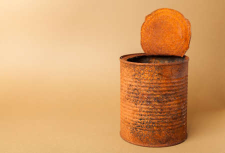 Old rusty tin can on beige backgroundの写真素材