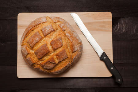 Round loaf bread on black wooden table