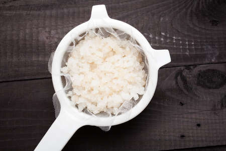 Water kefir grains into a plastic strainerの写真素材