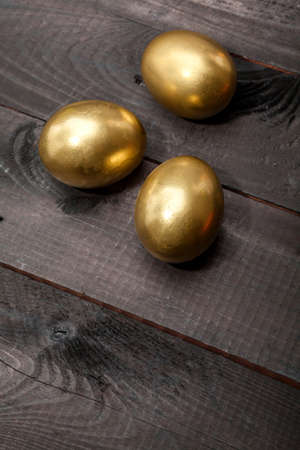 Golden Eggs on dark wooden backgroundの写真素材