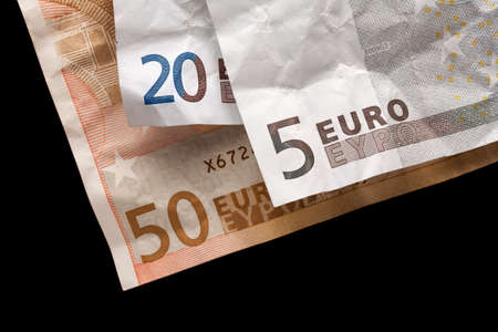 Crumpled euro money on black background
