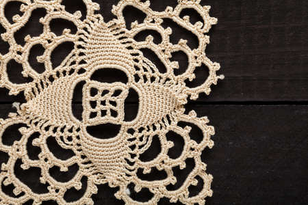Traditional handmade embroidery made with thin twine in Greece on black wooden tableの写真素材