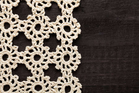 Traditional handmade embroidery made with thin twine in Greece on black wooden tableの写真素材