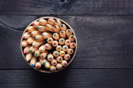 Color pencils on dark wooden backgroundの写真素材