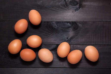 Brown eggs on dark wooden background