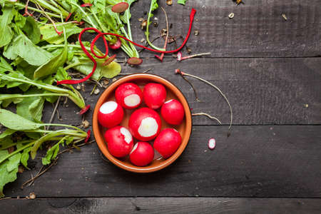 Large bunch of fresh radish on dark boardsの写真素材