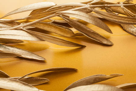 Golden branches of olive tree on golden backgroundの写真素材