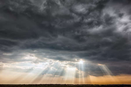 Stormy sky with a dramatic sunrays between the clouds on spring evening in Greece
の写真素材