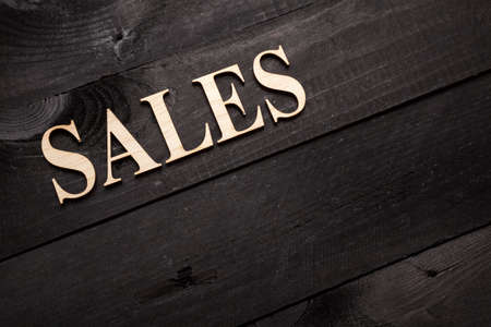 Wooden letters forming word SALES written on black wooden backgroundの写真素材