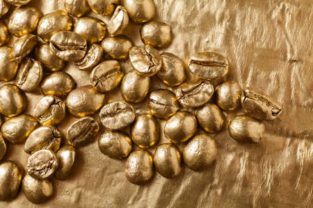 Golden coffee beans on golden backgroundの写真素材
