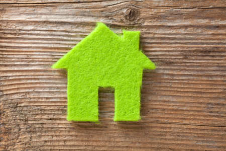 Green small house on wooden backgroundの写真素材