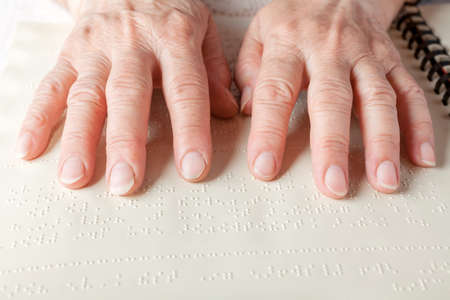 Blind old woman reading text in braille languageの写真素材