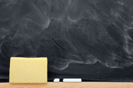 Blank blackboard with chalks and eraser