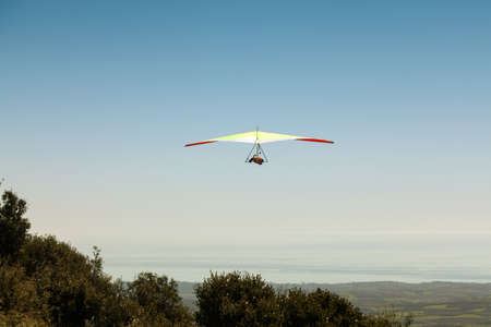 Hang glider flying over a mountain in Greece in a very clear, sunny day