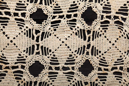 Traditional handmade embroidery made with thin twine in Greece on black wooden tableの写真素材