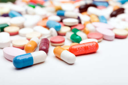 Pills and capsules on white background